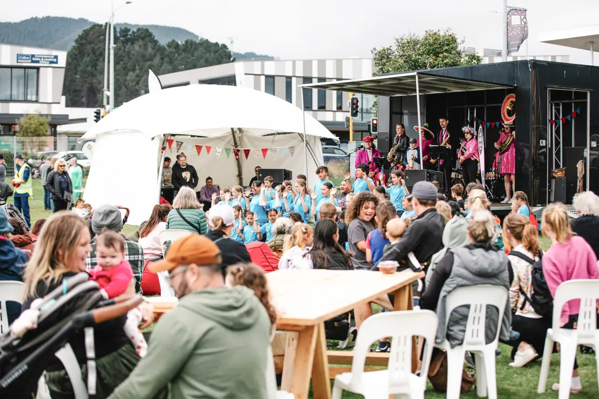 Band performing at a stage and demonstrations before a big crowd at the Kāpiti Strawberry Festival