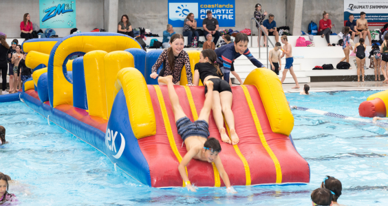 Kids playing on the inflatable obstacle course at one of our SPLASH! sessions at Coastlands Aquatic Centre