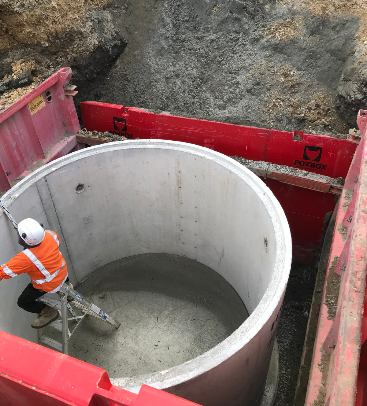 Contractor working on installation of large concrete stormwater pipes